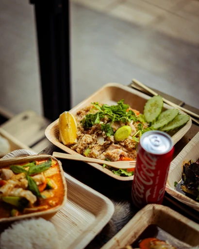 Stekt ris med ägg, grönsaker, gurka och citron i takeaway-box